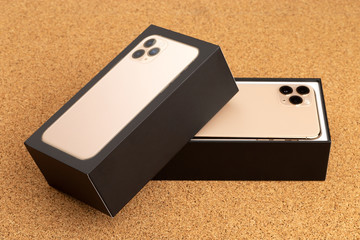 Smartphone on cork surface. A popular smartphone and box close-up.