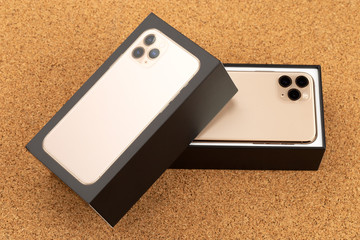 Smartphone on cork surface. A popular smartphone and box close-up.
