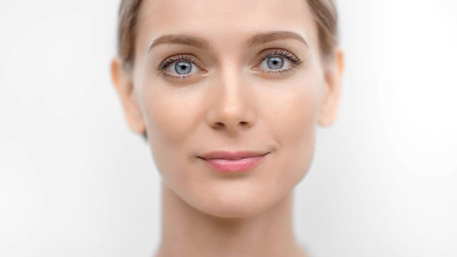 Close-up face smiling adorable flawless female model with perfect skin looking at camera