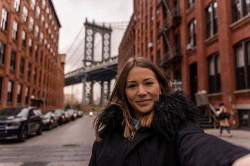 woman taking a selfie near the manhattan bridge in new york
