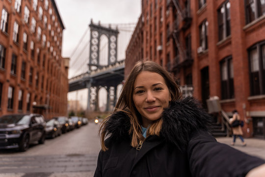 woman taking a selfie near the manhattan bridge in new york