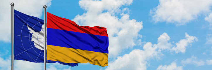 Antarctica and Armenia flag waving in the wind against white cloudy blue sky together. Diplomacy concept, international relations.