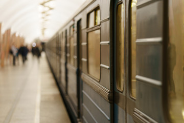 Defocused photography of Moscow subway station. Image of arriving train and people on the platform.