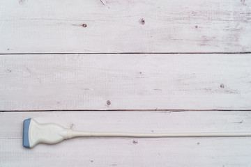 Ultrasound probe on white background layed out flat with blank space for text