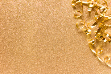 Fototapeta na wymiar Golden ribbon arranged on the right side on golden backgound