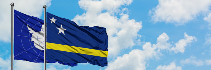Antarctica and Curacao flag waving in the wind against white cloudy blue sky together. Diplomacy concept, international relations.