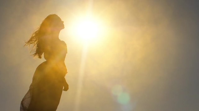 Silhouette of a woman against sun