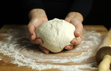 Preparare la tradizionale pasta fatta in casa. Primo piano delle mani della donna che impastano...