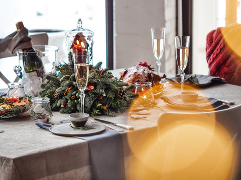 Table served for Christmas dinner. Beautiful served table with fir branches. Holiday setting in hygge style. Hygge Christmas, image with bokeh