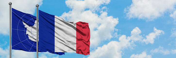 Antarctica and France flag waving in the wind against white cloudy blue sky together. Diplomacy concept, international relations.