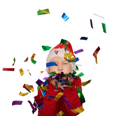 Christmas little kid blowing confetti, teen boy wearing a Santa hat and a red sweater, isolated on white background. Christmas holiday.