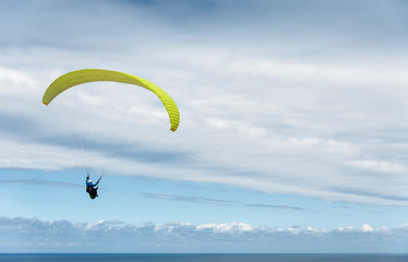A paraglider flies over the Atlantic Ocean off the coast of the Basque Country (Spain).