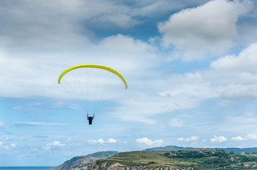 A paraglider flies over the Atlantic Ocean off the coast of the Basque Country (Spain).