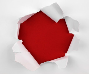 Hole ripped in paper on red