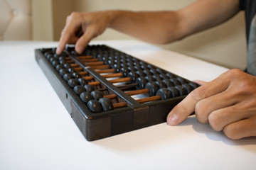 Young male hands holding old abacus performing addition, subtraction, division and...