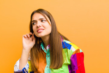 young pretty woman looking serious and curious, listening, trying to hear a secret conversation or...