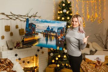 girl holds photo canvas as a christmas present