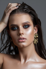 Young beautiful sexy model with a bright blue eyes, fashion make up, perfect skin, fashion earrings...