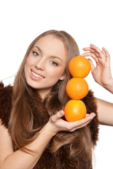 Portrait of young woman posing with oranges