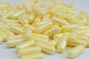 Fototapeta na wymiar Background of many yellow medicine capsules
