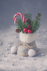 Little Christmas tweed retro boot with fir tree branches, cones and candy canes, postcard concept