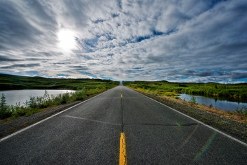 Road to Horizon with Cloudy Sky and Water
