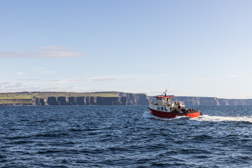 Fototapeta premium Boat going to Cliffs of Moher