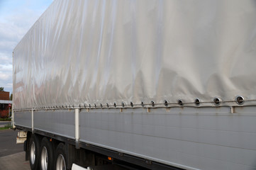 View of the tarpaulin covering the semi-trailer of the truck. Truck transport. - obrazy, fototapety, plakaty