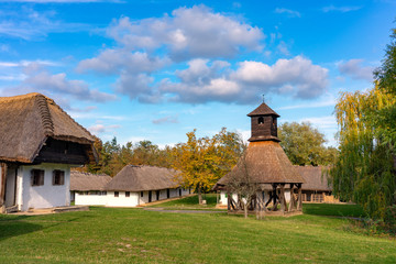 Historical old hungarian village with straw roof houses a bell tower
