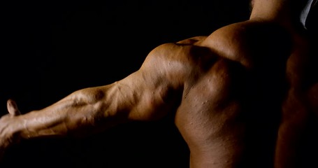 close up muscular male body rear view in a dark room professional athlete taking anabolic steroids