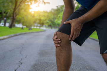 Young healthy man runner  injured their knees from running.