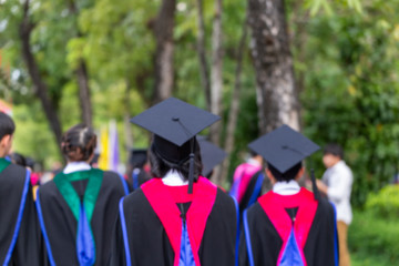 Blurred image back side view a group higher education graduation of graduates during commencement....