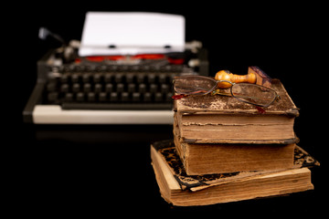 Typewriter and old books. Writer's place of work.