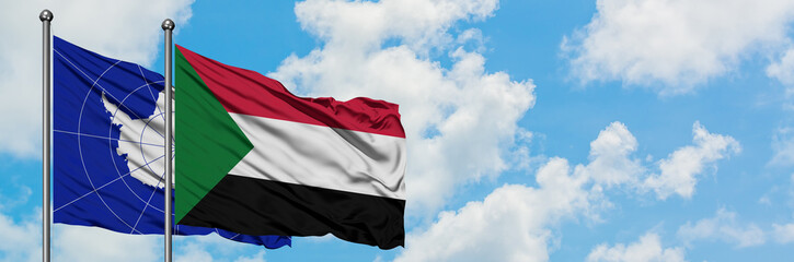 Fototapeta na wymiar Antarctica and Sudan flag waving in the wind against white cloudy blue sky together. Diplomacy concept, international relations.
