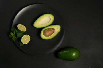 Avocado with limes on a dark backgroung