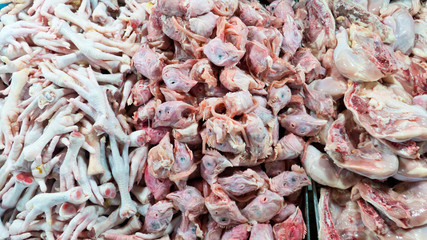 Paws chicken on the counter market. Chopped chicken. Chicken heads. cold chicken feet and head after slaughtering