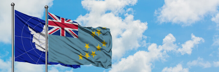 Antarctica and Tuvalu flag waving in the wind against white cloudy blue sky together. Diplomacy...