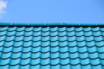 Turquoise metal tiles on roof of the house. Modern roofing materials