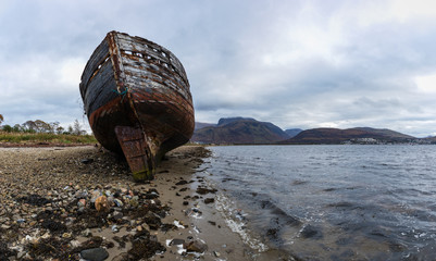 an abandoned fishing boat on the shore near fort william in the argyll region of the highlands of...