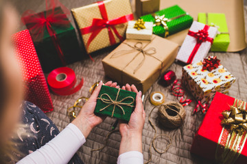 Fototapeta na wymiar Gift wrapping. Woman packs holiday gifts at home..