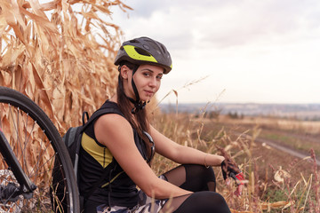 smiling girl resting near bicycle in field