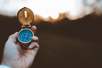 Person holding a compass with a blurred background