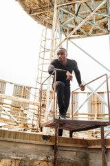 Fototapeta premium Handsome African American man on the roof of an old house