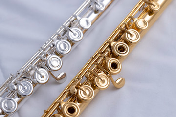 A gold and silver plated flute on a white background. A music instrument common in symphony...