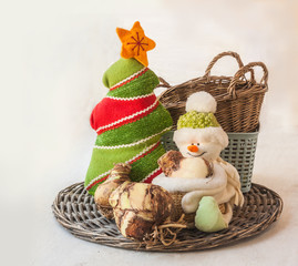 Bulbs of hippeastrum (amaryllis) next to a snowman and Christmas tree (mass-produced). Concept