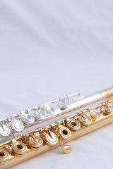 A gold and silver plated flute on a white background. A music instrument common in symphony...