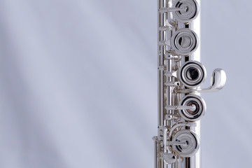 A silver plated flute on a white background. An instrument common in the symphony orchestra
