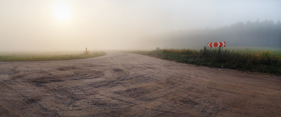 Gravel road and fog. Rural landscape. Panoramic shot.