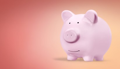 Doctor with stethoscope holding pink piggy bank