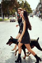 Two young fashion models with dog